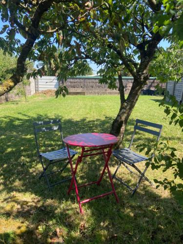 une table et deux chaises assises à côté d'un arbre dans l'établissement STUDIO A 20 MIN DU PUY DU FOU, à Mesnard-la-Barotière