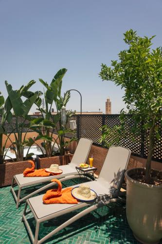two lounge chairs and a table with food on it at Riad Anya & SPA in Marrakech