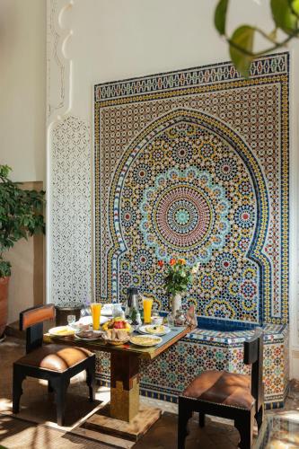 a dining room with a table and a mosaic wall at Riad Anya & SPA in Marrakech