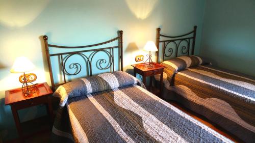 2 camas en una habitación con 2 lámparas en las mesas en Abadia de Cal Bessó, en Alberola