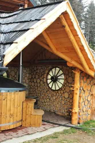 a log cabin with a wooden roof and a stove at Domek u Johnnego in Piwniczna-Zdroj