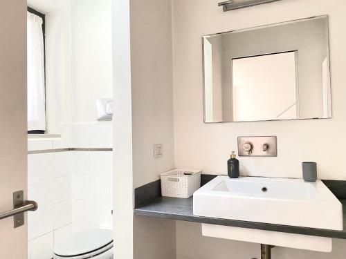 une salle de bain blanche avec un lavabo et un miroir dans l'établissement Sant Ambrogio Courtyard Room in shared flat, à Milan