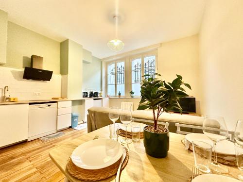 une salle à manger avec une table et une plante en pot dans l'établissement Le Général, optimal et central, à Limoges