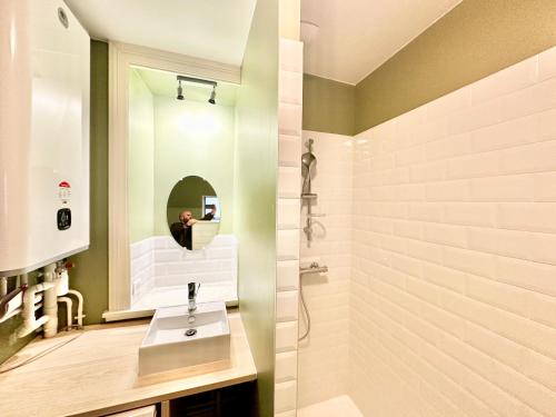 une salle de bain avec un lavabo et un miroir dans l'établissement Le Général, optimal et central, à Limoges