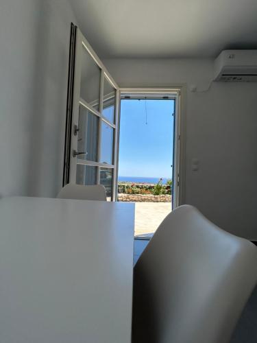 a room with a table and a view of the ocean at Thea Vouno Studios in Agia Pelagia Kythira