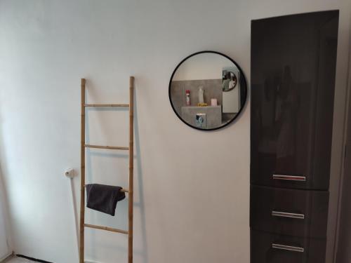 a mirror hanging on a wall next to a shelf at La pergola in Valros