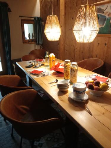 a wooden table with a bowl of fruit and lights at Patatouc Country House - 15 minuti di cammino da Limonetto in Limone Piemonte