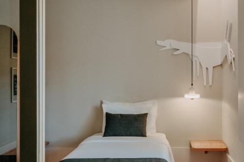 a bedroom with a bed with a green pillow at Casa das Lérias in Amarante