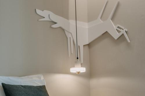 a ceiling light with a bird sculpture on a wall at Casa das Lérias in Amarante