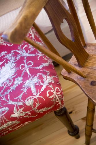 a wooden chair with a red pillow on it at York House Lisboa Hotel in Lisbon