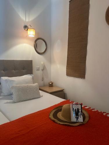 a bedroom with a bed with a hat on it at Maison du Lierre Bordeaux Centre ville in Bordeaux