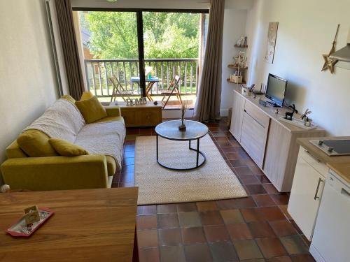 un salon avec un canapé et une table dans l'établissement Superbe studio terrasse plein sud, à Saint-Chaffrey