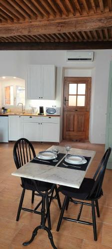 une cuisine avec une table, deux chaises, une table et des chaises dans l'établissement Studio Isaline RDC, à Saint-Ambroix
