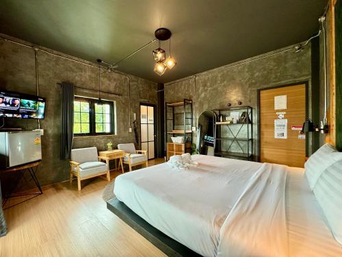 a bedroom with a large white bed and a tv at Tanwa House in Chiang Mai