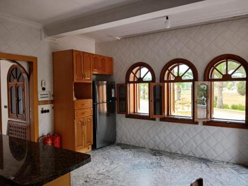 a kitchen with a refrigerator and some windows at Villa Cabo in Martil