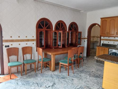 a kitchen with a wooden table and chairs at Villa Cabo in Martil
