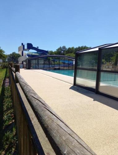 une passerelle en bois à côté d'un bâtiment et d'une rivière dans l'établissement L'orée du bois, à La Boissière-de-Montaigu