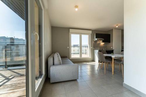 un salon avec un canapé et une table dans l'établissement Bordeaux Mérignac appartement 2 Pièces - 2 Terrasses, à Mérignac