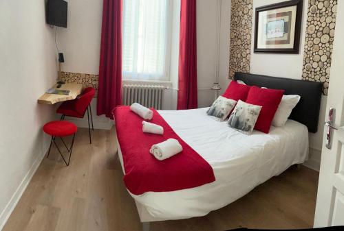 une chambre avec un grand lit avec des oreillers rouges dans l'établissement Hotel Regina, à Saint-Nectaire