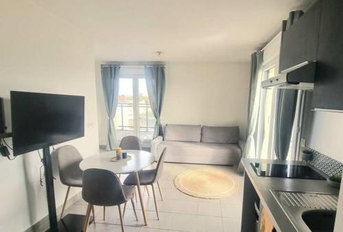 une cuisine et un salon avec une table et des chaises dans l'établissement Bordeaux Mérignac appartement 2 Pièces - 2 Terrasses, à Mérignac