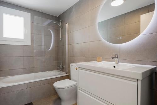 a bathroom with a sink and a toilet and a mirror at Casa Los Vecinos - Luxury Rooftop Penthouse in Estepona