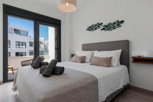 a bedroom with a large bed with a large window at Casa Los Vecinos - Luxury Rooftop Penthouse in Estepona
