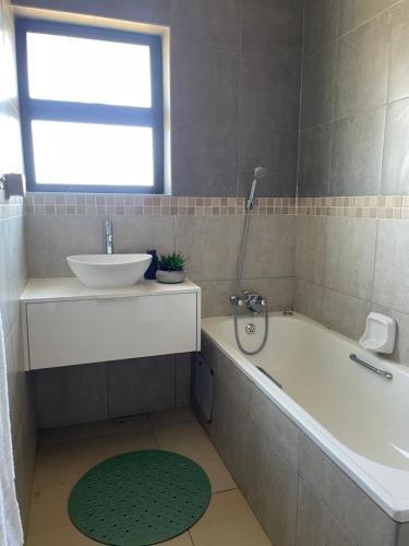 ein Badezimmer mit Waschbecken und Badewanne in der Unterkunft Grey Net in Palatswe