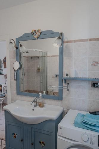 a bathroom with a sink and a mirror and a toilet at I Ginepri B&B in Portoscuso