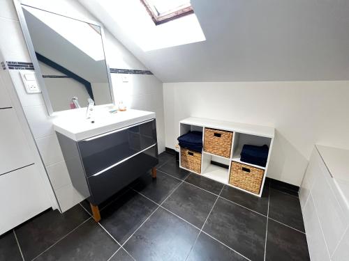 une salle de bain avec un lavabo et un miroir dans l'établissement Maison, chaleur, chaleureuse au calme et spa, à Varetz