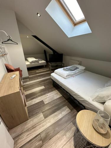- une chambre mansardée avec un lit et une lucarne dans l'établissement Maison, chaleur, chaleureuse au calme et spa, à Varetz
