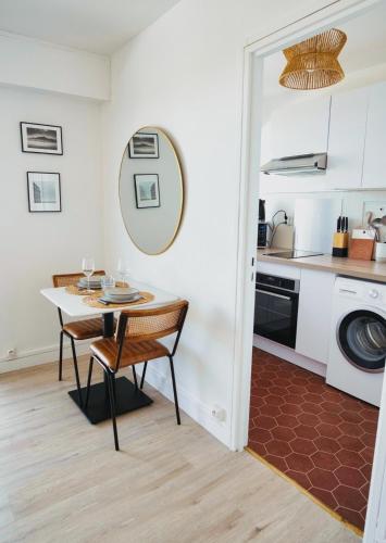 - une cuisine et une salle à manger avec une table et un évier dans l'établissement L Andreoni, grand studio à 5 min du métro l Parking & Netflix, à Maisons-Alfort