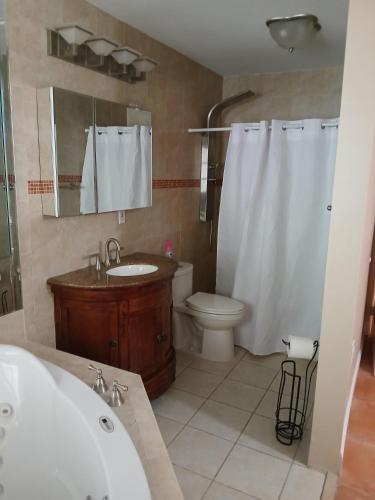 a bathroom with a tub and a toilet and a sink at Beautiful Miami Home in Miami