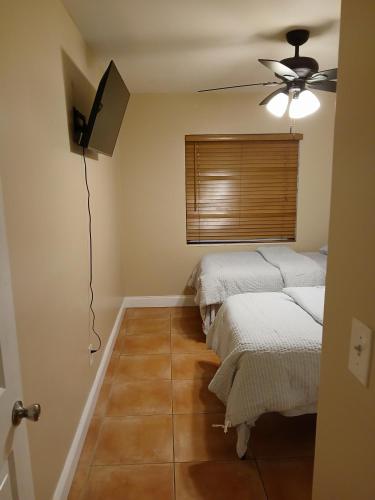 a room with two beds and a ceiling fan at Beautiful Miami Home in Miami