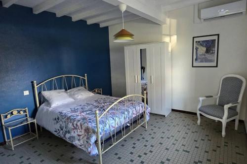 a bedroom with a bed and two chairs at Ferme rénovée tout confort en pleine campagne in Larbey