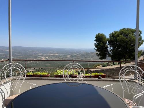 a table and chairs on a balcony with a view at La Casa Escondida in Sabiote