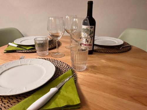 a table with plates and glasses and a bottle of wine at Ca' Pecina - casa vacanze in Dolceacqua