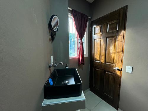 a bathroom with a black sink and a window at Tiny Room El Mangal B&B in Suchitoto