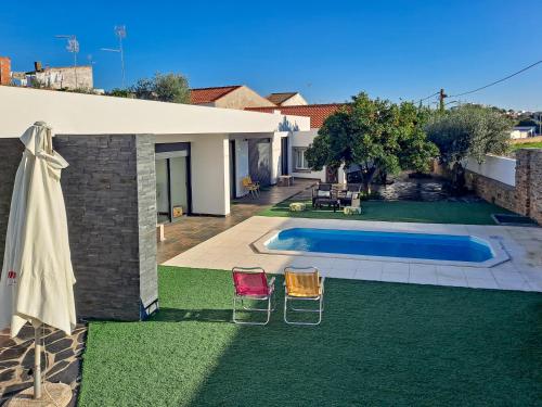a yard with two chairs and a swimming pool at Mourão Retreat in Mourão