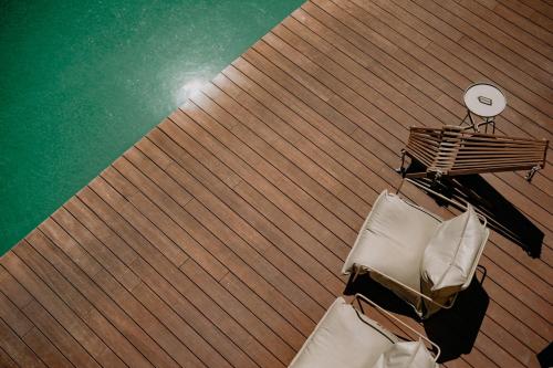 an overhead view of two chairs on a wooden deck at Casa das Lérias in Amarante