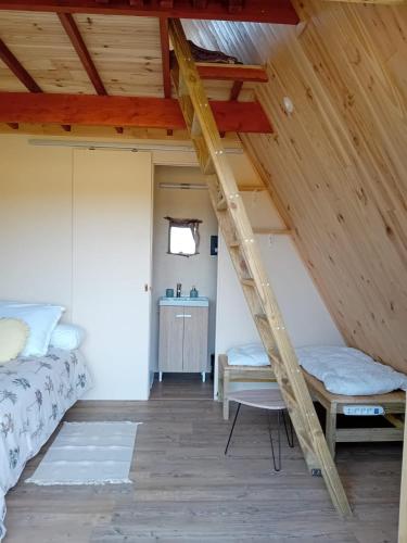 - une échelle dans une chambre avec un lit et un bureau dans l'établissement Le Chalet dans les Près, à Les Pégués