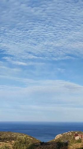 a view of the ocean and a blue sky with clouds at Thea Vouno Studios in Agia Pelagia Kythira