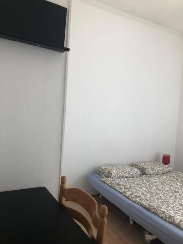 a bedroom with a bed and a table and a chair at Chambre de 9m2 in Bagnolet