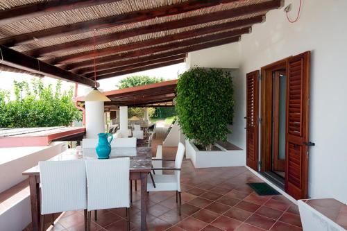 a dining area with a table and white chairs at Villa Mulino Al Vento in Lipari