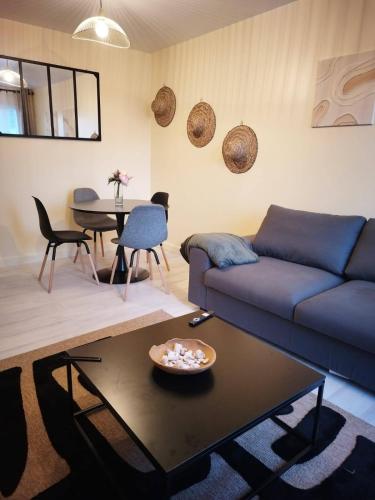 un salon avec un canapé bleu et une table dans l'établissement Appartement rénové pour 4, à Bezons