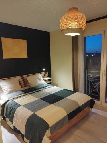 une chambre avec un lit et une grande fenêtre dans l'établissement Appartement rénové pour 4, à Bezons