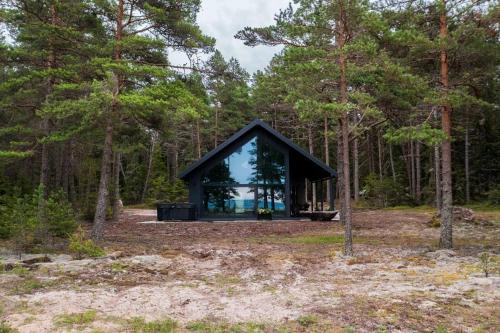 a glass house in the woods at Dirhami jacuzzi villa in Spithami