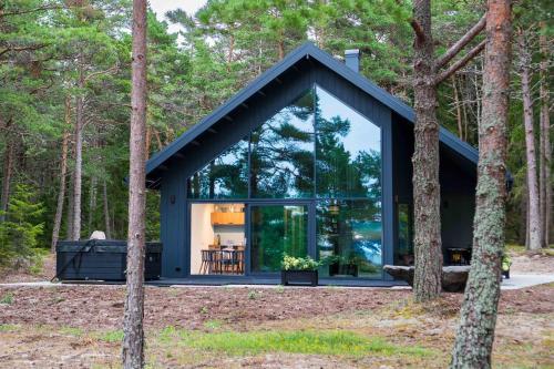 a glass house in the woods with trees at Dirhami jacuzzi villa in Spithami