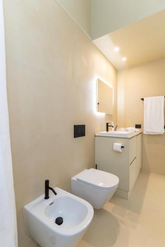 a white bathroom with a toilet and a sink at Elbitat Homes in Bagnaia