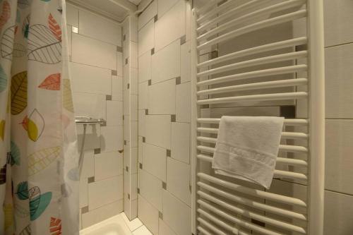 La salle de bains est pourvue d'une douche et d'une serviette blanche. dans l'établissement Le Clair de Lune, à Dinard