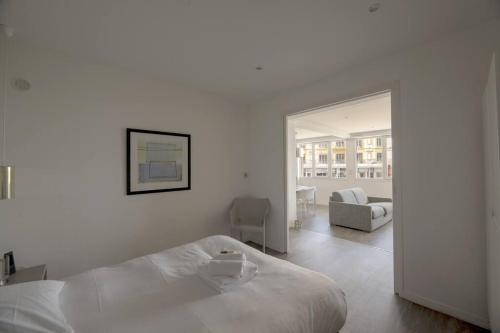 - une chambre blanche avec un lit et un salon dans l'établissement Le Clair de Lune, à Dinard